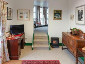 a living room with a staircase with a television and a fireplace at The Gingang in Hexham