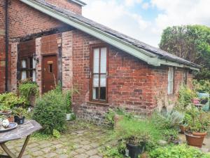 una casa de ladrillo con un jardín delante de ella en The Toolshed, en Warrington