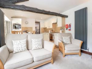 a living room with a couch and two chairs at Woodloft Cottage in Elterwater