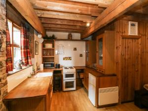 a kitchen with wooden cabinets and a stove top oven at The Toolshed in Warrington