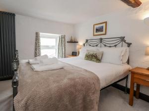 a bedroom with a large bed and a window at Woodloft Cottage in Elterwater
