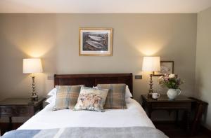 a bedroom with a bed with two lamps and two pillows at D'Arcy Spice, The Apple Rooms in Stockbridge