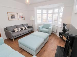 a living room with a couch and a chair and a piano at Shileen in Seahouses