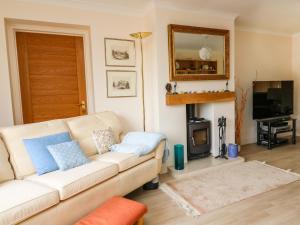 a living room with a white couch and a fireplace at Trevonnen in Brecon