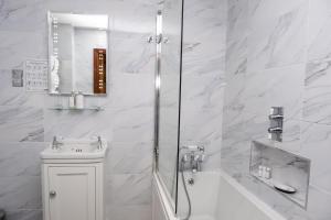 a white bathroom with a tub and a sink and a shower at Arthur Turner, The Apple Rooms in Stockbridge