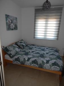 ein Bett in einem Schlafzimmer mit einem Fenster in der Unterkunft Apartman Zvezda vodilja in Veternik