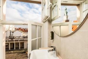 a bathroom with a mirror and a sink and a window at Sleep in Hostel & Apartments Stary Rynek in Poznań +119 photos