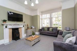 uma sala de estar com um sofá e uma lareira em Orchard Lodge em Lytham St Annes