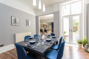 a dining room with a table and blue chairs at Orchard Lodge in Lytham St Annes