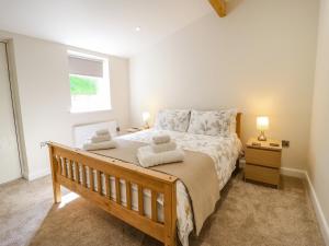 a bedroom with a large bed with two towels at 3 Barn Cottages in Halifax