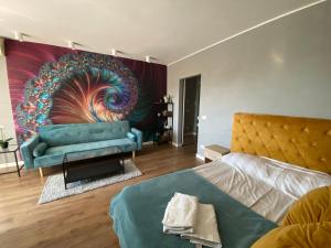 a bedroom with a blue bed and a couch at National Park Boutique Studio in Bucharest