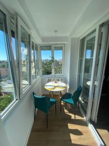 a room with a table and chairs and windows at National Park Boutique Studio in Bucharest