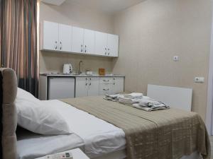 um quarto com uma cama e uma cozinha com armários brancos em Pushkin street Pearl em Kutaisi