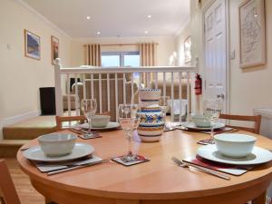 a wooden table with plates and wine glasses on it at Woodside Cottage in Troutbeck Bridge