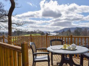 a patio with a table and chairs on a deck at Woodside Cottage in Troutbeck Bridge