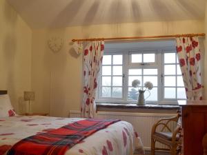 Schlafzimmer mit einem Bett und einem Fenster in der Unterkunft Ivy Cottage in South Wingfield