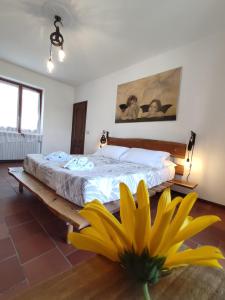 una camera da letto con un letto con un fiore giallo sul pavimento di Ca di me a La Morra