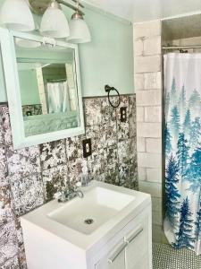 een badkamer met een witte wastafel en een spiegel bij Madame Isabelle's House in New Orleans