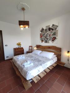 una camera con un grande letto con struttura in legno di Ca di me a La Morra