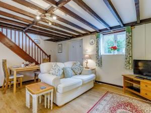 a living room with a white couch and a table at The Tack Room - Uk30438 in Kingsbury Episcopi