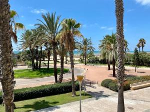 a park with palm trees and a wine glass at Villa palacio Playa y piscina Grupo AC Gestion in Cádiz