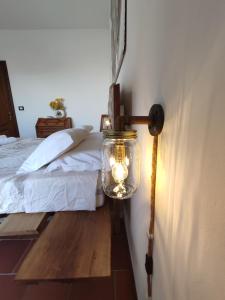une lumière sur un mur à côté d'un lit dans l'établissement Ca di me, à La Morra