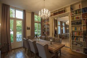 a dining room with a table and chairs and bookshelves at Boutique B&B Villa Heidetuin in Bergen op Zoom