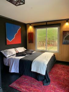 a bedroom with a large bed with a large window at EL PAISAJE MAS SOÑADO in El Retiro