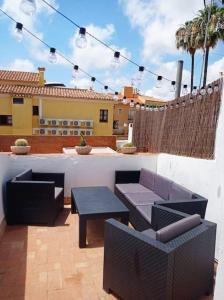 un patio con 2 sofás, una mesa y sillas en casa costa dorada con piscina, en Creixell