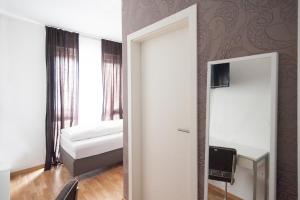 a room with a mirror and a bedroom with a bed at Hotel Garni am Arbach in Eningen unter Achalm