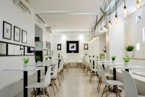 a long dining room with white tables and chairs at Believe Madero Hotel in Buenos Aires