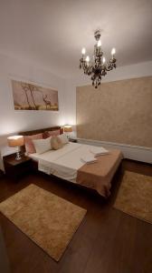 um quarto com uma cama grande e um lustre em Ambiennt em Bucareste
