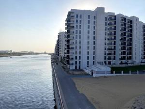 een groot wit gebouw aan het strand naast het water bij Brand New 1 Bedroom, Vacation Home! in Abu Dhabi