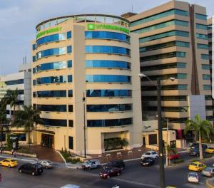un gran edificio con coches estacionados en un estacionamiento en Ecusuites Empresarial Torre Sol II & Torre Medica 98, en Guayaquil