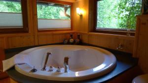 - dużą białą wannę w łazience z 2 oknami w obiekcie Luxus Chalet Mühlermoos w mieście Ramsau im Zillertal
