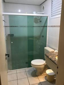 une salle de bain avec toilettes et douche en verre dans l'établissement FLAT AMARILIS RIVIERA DE SÃO LOURENÇO, à Bertioga 9 autres photos