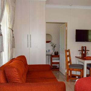sala de estar con sofá y comedor en Olive Country Lodge - Eswatini, en Ngwempisi