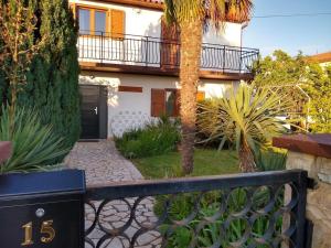 une maison avec une clôture et un palmier dans l'établissement Adriana Holiday house Nova Vas, à Nova Vas