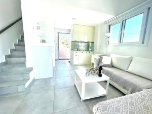 un soggiorno bianco con divano e scala di Syllas Grand Resort - Prestigious Villa 8 a Edipsos