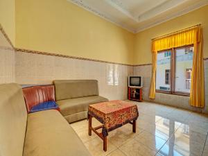 sala de estar con sofá, mesa y TV en OYO Life 91677 Hotel Citra Dewi 3, en Semarang