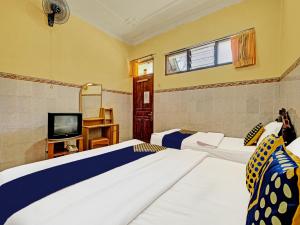 1 dormitorio con 2 camas y TV en OYO Life 91677 Hotel Citra Dewi 3, en Semarang