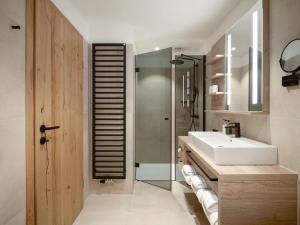a bathroom with a sink and a shower and a mirror at Hotel Bütgenbacher Hof in Butgenbach