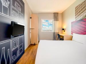 a hotel room with a bed and a flat screen tv at ibis Sao Paulo Interlagos in Sao Paulo