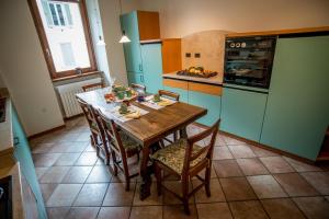 una cocina con una mesa de madera y algunos armarios verdes en B&B del Gran Ducato di Alzano Sopra, en Alzano Lombardo
