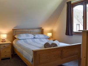 a bedroom with a bed with two pillows and a window at Trevithick Lodge in Hayle