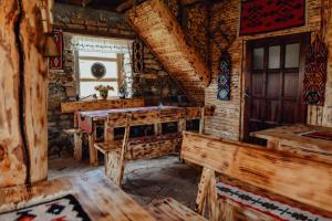 a room with a table and benches in a log cabin at Vidikovac Uvac in Družiniće