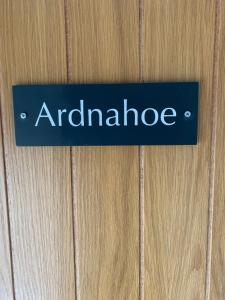 a blue sign on a wooden door with the word antidenride at Lochindaal Hotel in Port Charlotte