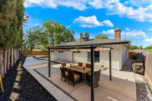 eine Terrasse mit Tisch und Sonnenschirm in der Unterkunft Fully Renovated 4 Bedroom Home with Pool! in Roseville