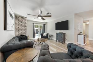 ein Wohnzimmer mit zwei Sofas und einem Flachbildfernseher in der Unterkunft Fully Renovated 4 Bedroom Home with Pool! in Roseville