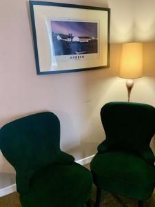 two chairs and a lamp in a room at Lochindaal Hotel in Port Charlotte